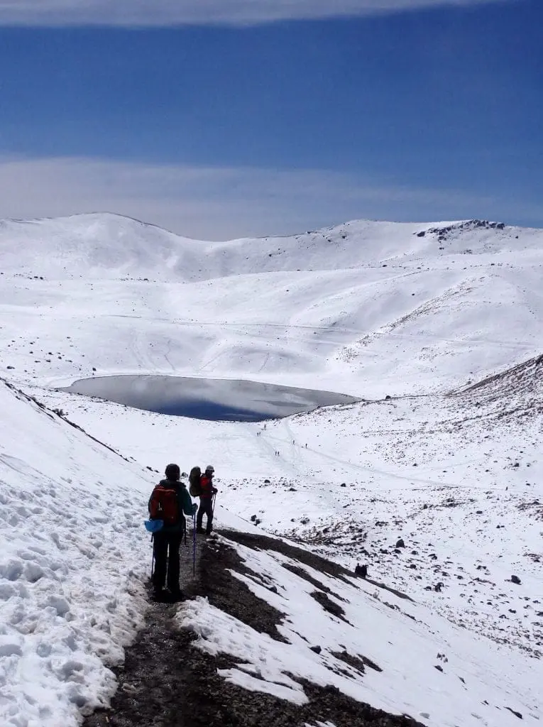 Nevado de Toluca winter climb with lake view surrounded by snow.
