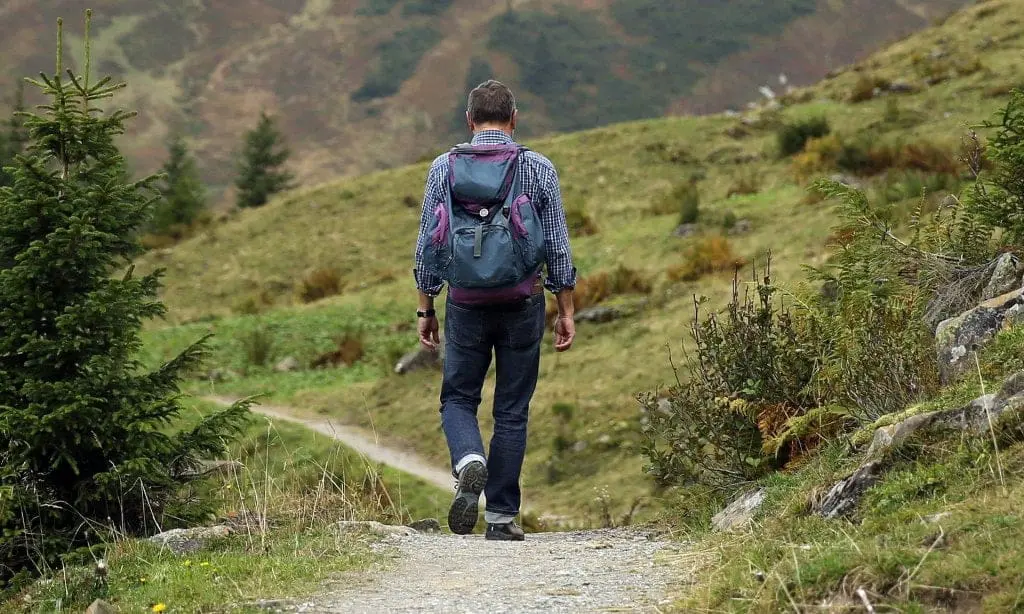 Man hiking on trail with backpack