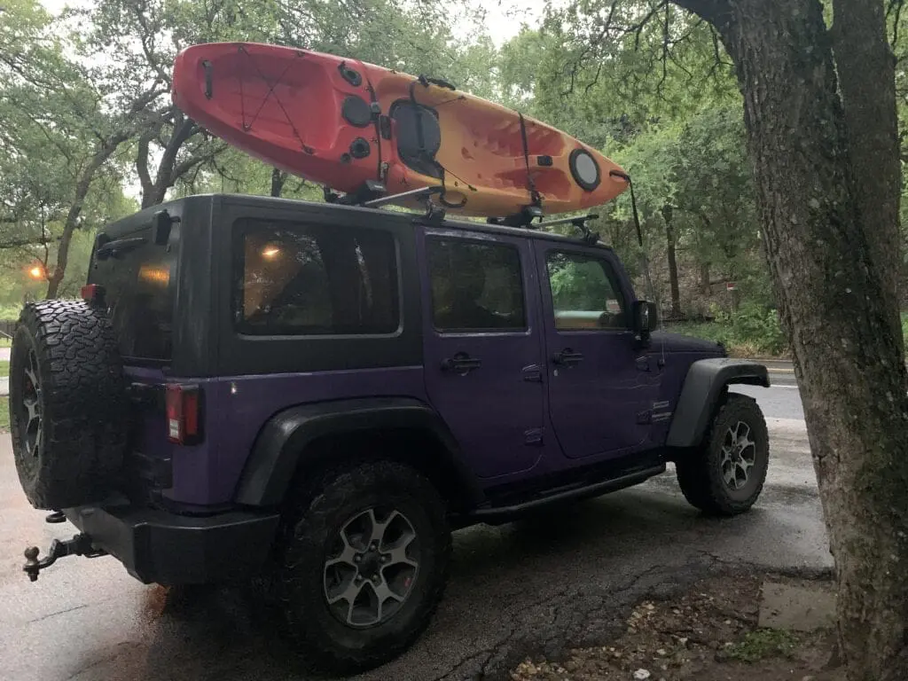 Thule Jeep Wrangler roof rack with kayak mounted on roof using thule J bars